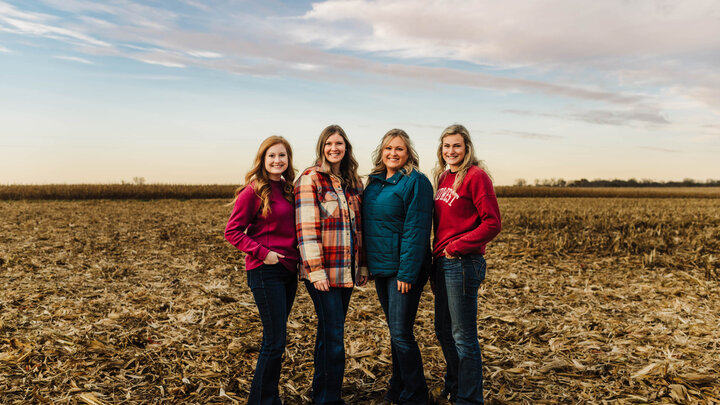 Women standing in a harvested field