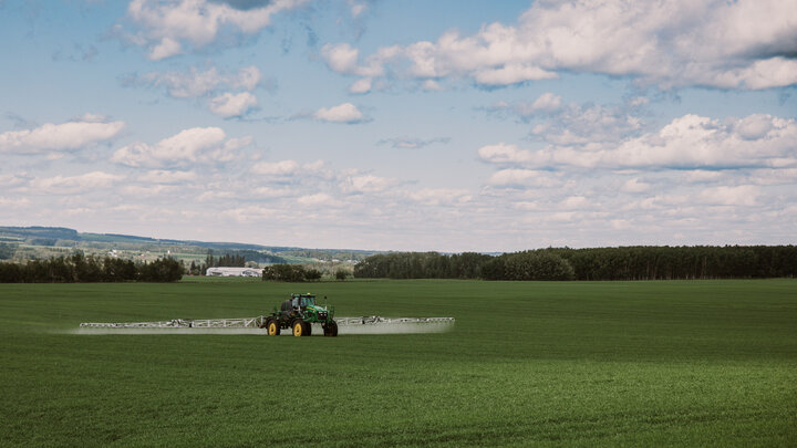 Sprayer applying pesticide in field