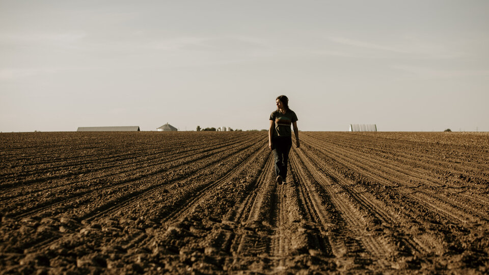 Woman walking in a field before planting 