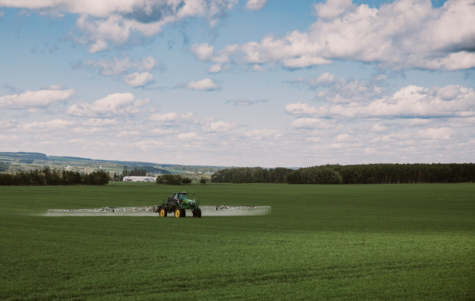 Sprayer applying pesticide in field