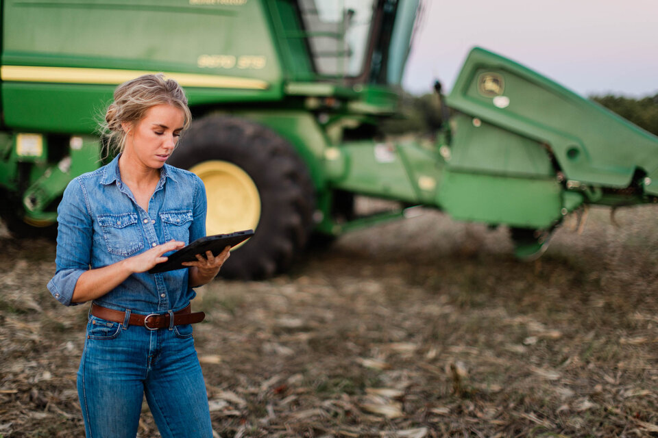 Woman looking at tablet in a harvest field